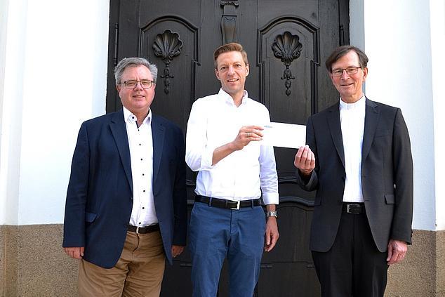 Von Links: Kirchenpfleger Edgar Rothammer, REWAG-Pressesprecher Martin Gottschalk und Pfarrer Helmut Brunner vor der Pfarrkirche Obertraubling. (Foto: Karl Matok)