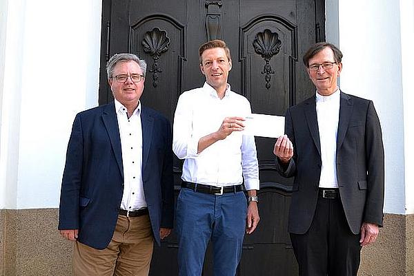 Von Links: Kirchenpfleger Edgar Rothammer, REWAG-Pressesprecher Martin Gottschalk und Pfarrer Helmut Brunner vor der Pfarrkirche Obertraubling. (Foto: Karl Matok)
