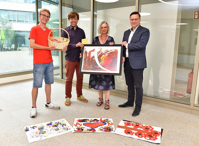 Von Links: Sebastian Lengfelder, Leiter der Caritas-Kinderbetreuung im Ankerzentrum; Michael Straube, Vorstand der Regensburger Eltern; Künstlerin Maria Kurzok und REWAG-Vorstand Bernhard Büllmann bei der Spendenübergabe im R-Werk. (Foto: Tino Lex)