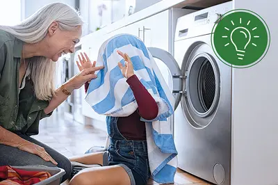 Frau mit Kind vor Waschmaschine