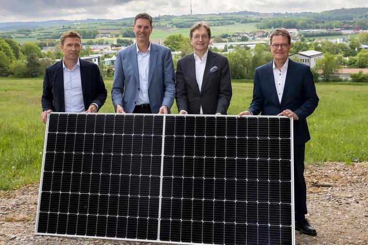 Die Geschäftsführer der beteiligten Unternehmen stehen hinter einem Solarmodul.