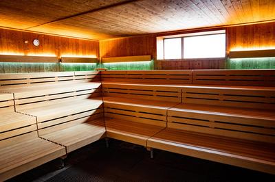 Innenraum einer Sauna mit mehrstufigen Holzbänken und indirekter Beleuchtung