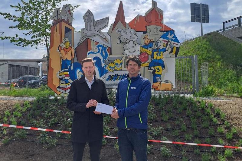 Spendenübergabe vor dem Kunstwerk.
